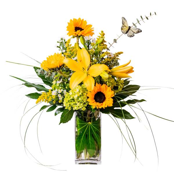 Yellow lilies and sunflowers in a clear glass vase with a butterfly accent
