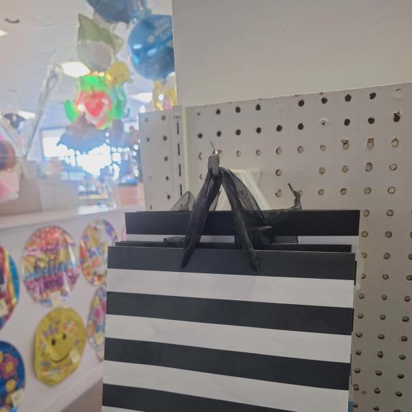 Black-and-white striped gift bag hanging on a display peg