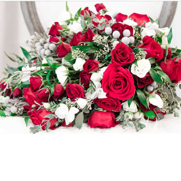 Bouquet of red and white roses with greenery and white berry accents