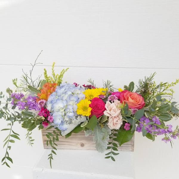 Colorful mixed flower arrangement in a wooden box