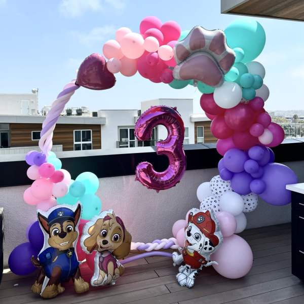 Colorful balloon arch with a large number 3 and Paw Patrol character balloons