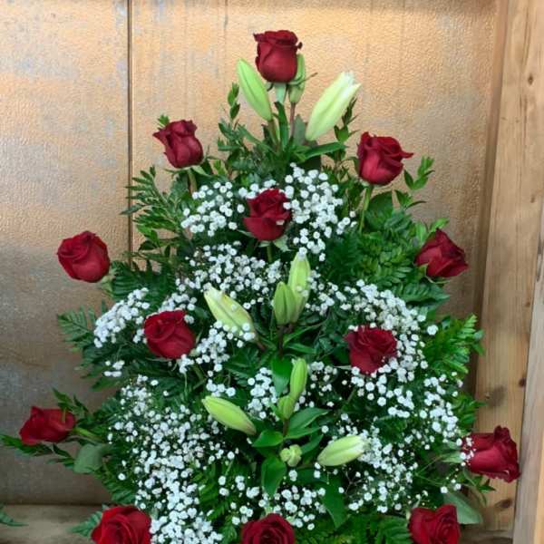 Tiered arrangement of red roses and white lilies with baby's breath