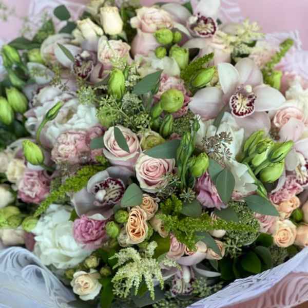 Large bouquet of pale pink and white flowers with green accents