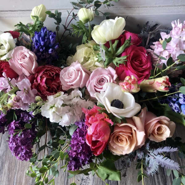 Mixed bouquet of roses, anemones, and hyacinths in pink, white, purple, and red