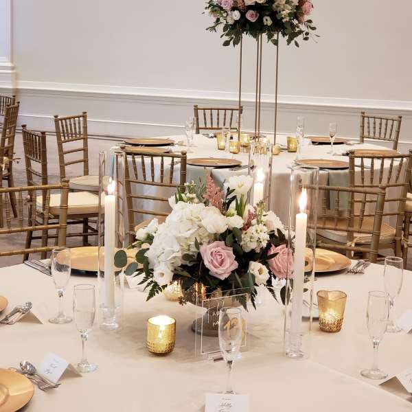 Floral centerpieces with pink and white roses on a banquet table