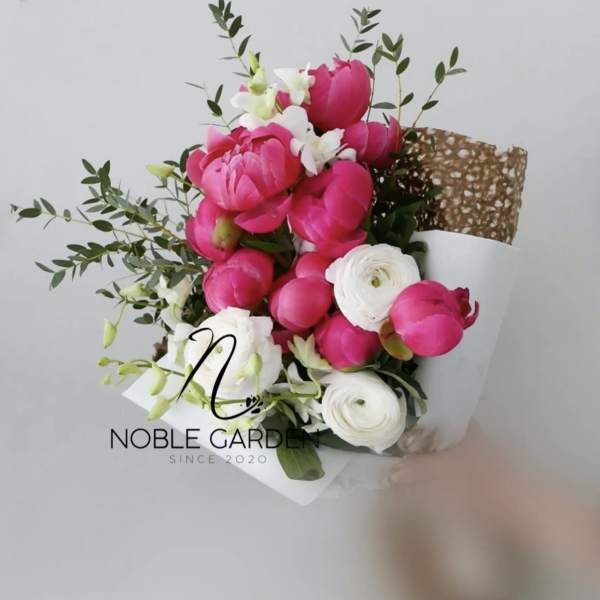 Bouquet of pink and white flowers wrapped in white paper