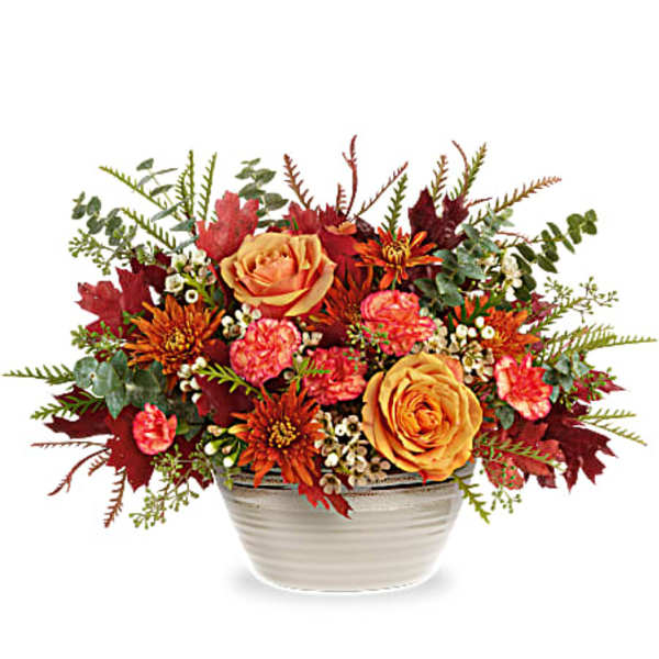 Autumn floral arrangement in a white bowl with orange and pink blooms
