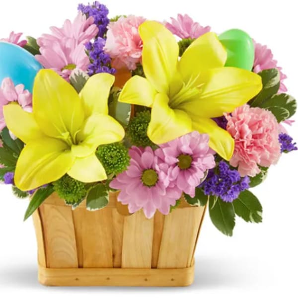 Colorful bouquet with yellow lilies and pink daisies in a wooden basket