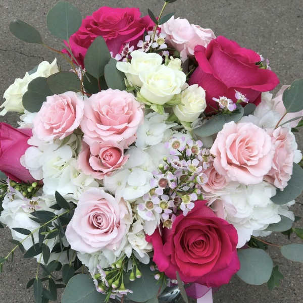 Bouquet of pink and white roses with eucalyptus in a glass vase
