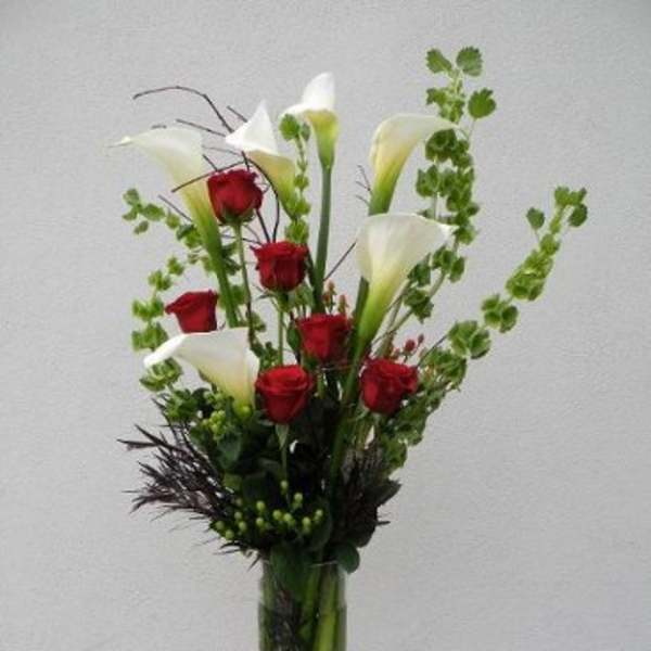 Tall vase arrangement with red roses and white calla lilies