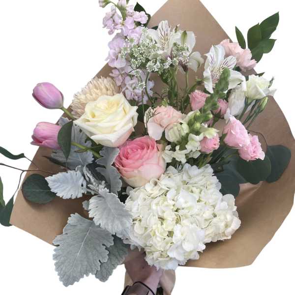 Hand-tied bouquet of pink and white flowers wrapped in brown paper
