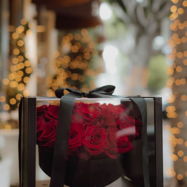 Box of red roses tied with a black ribbon