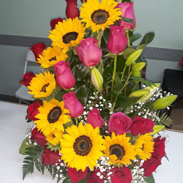 Bouquet of red and pink roses with yellow sunflowers and white baby's breath