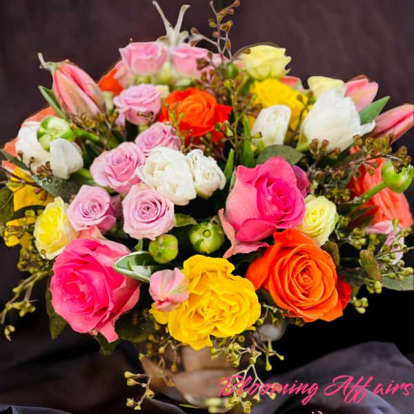 Bouquet of multicolored roses with a few tulips and berries