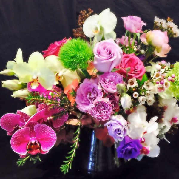 Mixed bouquet of pink, purple, white, and green flowers in a vase
