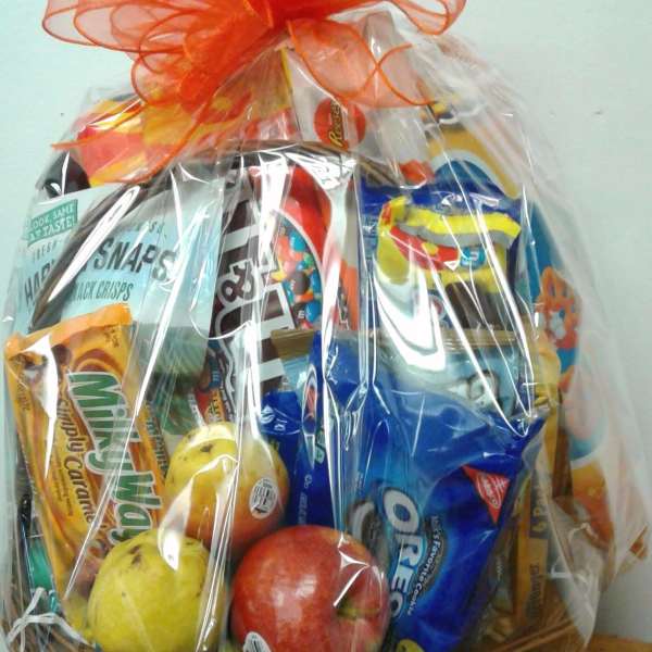 Gift basket of assorted snacks and fruit in a wicker basket