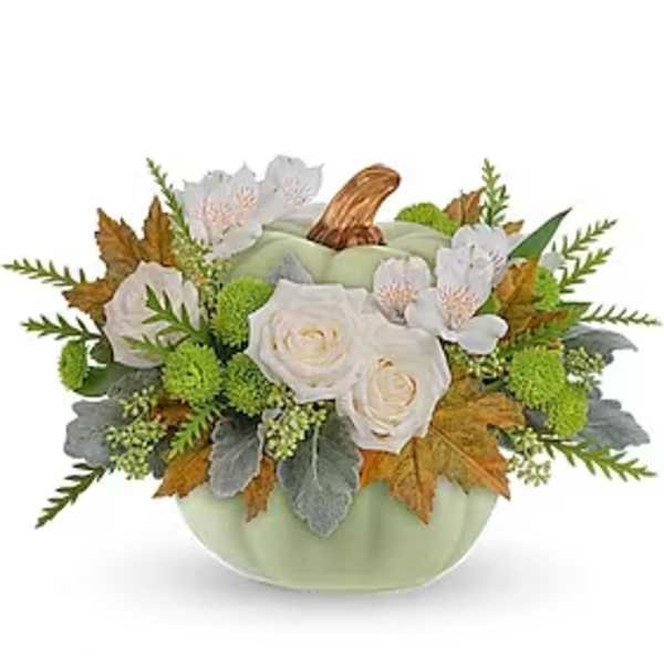White roses in a pale green pumpkin-shaped container with autumn leaves