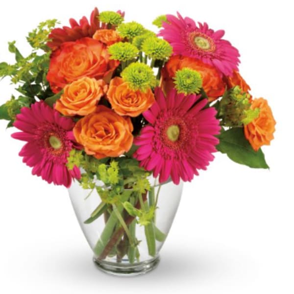 Bouquet of orange roses and pink gerbera daisies in a clear glass vase