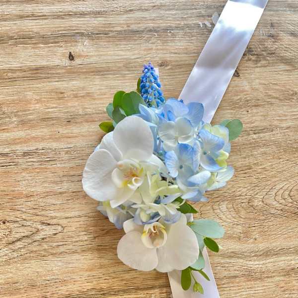 Blue and white floral wrist corsage with ribbon