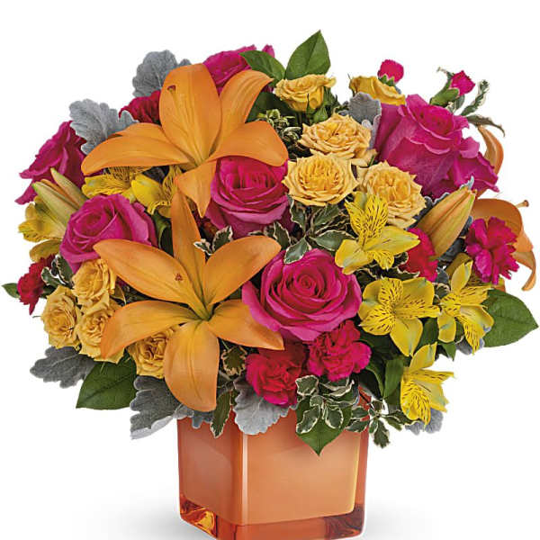 Bouquet of orange lilies, pink roses, and yellow flowers in an orange vase