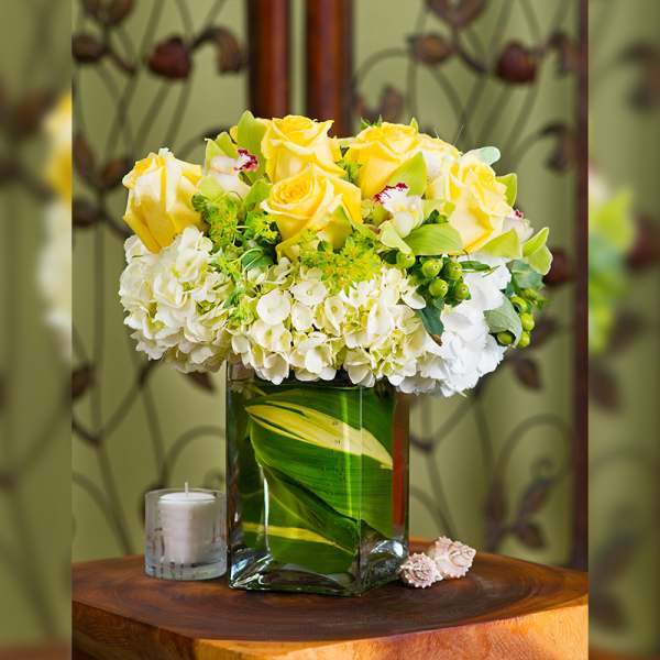 Yellow roses and white hydrangeas in a glass vase