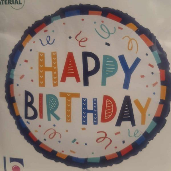 Round foil balloon with colorful Happy Birthday text and confetti accents