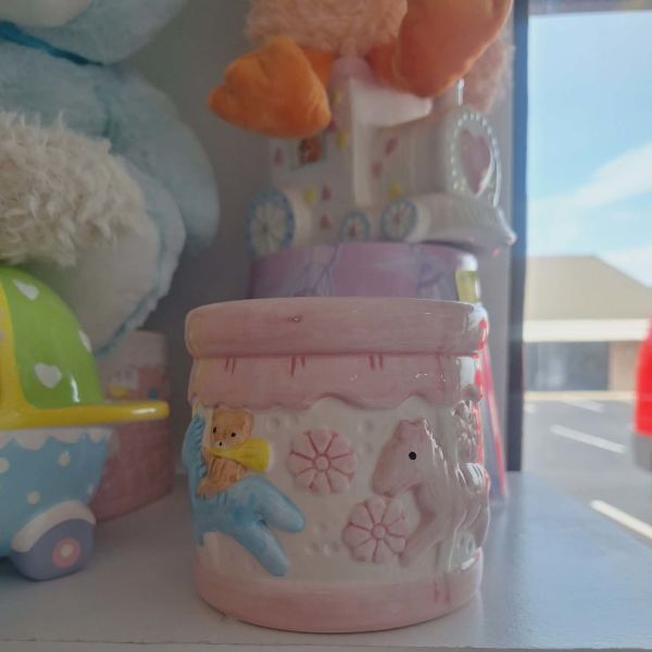 Pink ceramic jar with a teddy bear and horse reliefs