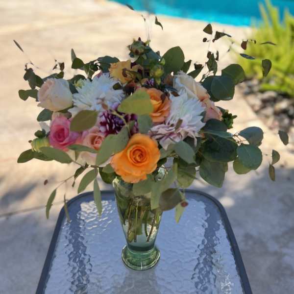 Mixed bouquet of roses and white blooms in a glass vase