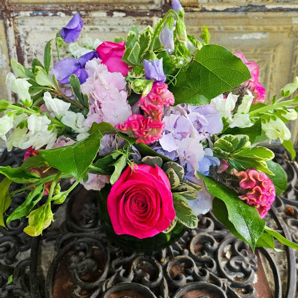 Mixed bouquet with a bright pink rose and purple and white flowers