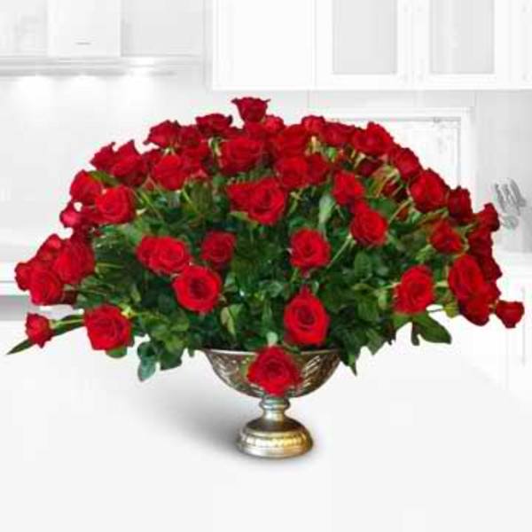 Large arrangement of red roses in a gold pedestal vase