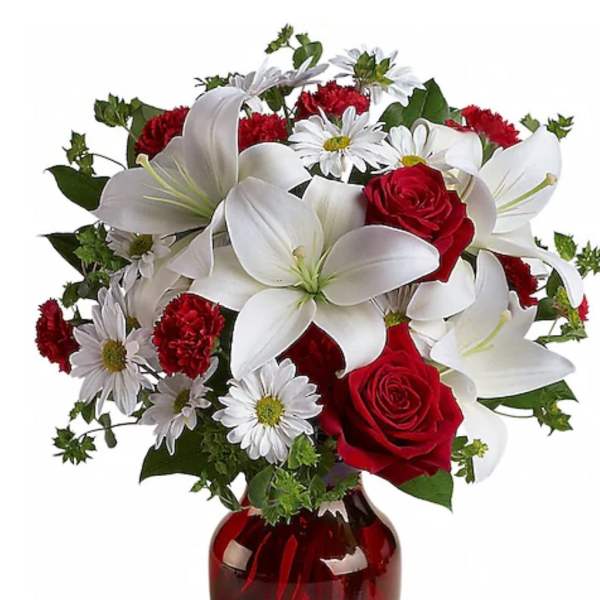 Red roses and white lilies in a red glass vase