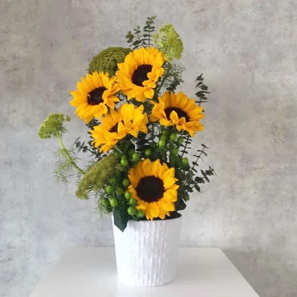 Sunflower arrangement in a white textured vase