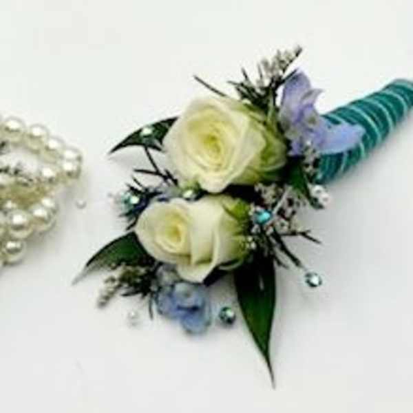 White rose corsage with blue ribbon and pearl accents