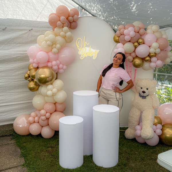 Pastel balloon arch with a teddy bear and baby shower sign