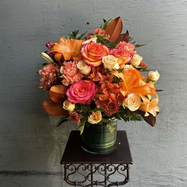 Bouquet of orange and pink roses in a green vase