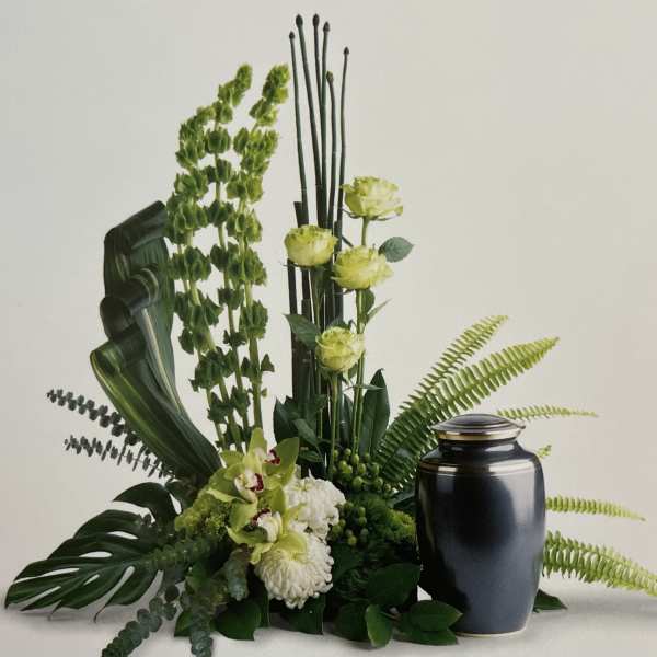 Green floral arrangement with a black urn