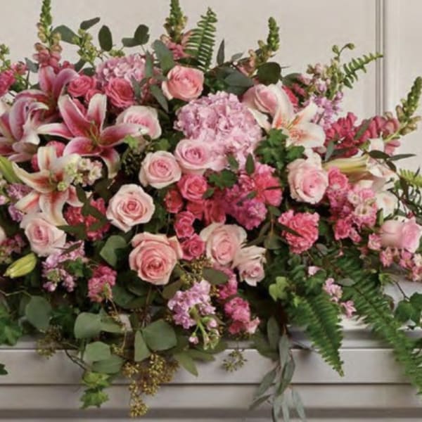 Large pink floral casket spray with roses and lilies