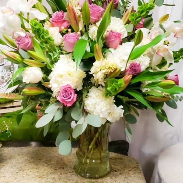 Large bouquet of pink and white flowers in a glass vase