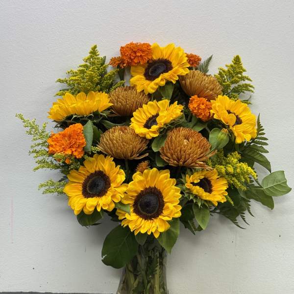 Sunflower and marigold bouquet in a clear glass vase