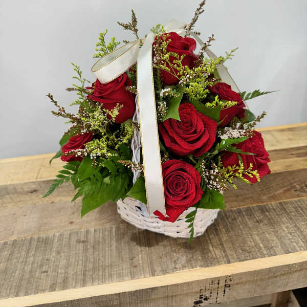 Basket of red roses with a white ribbon bow