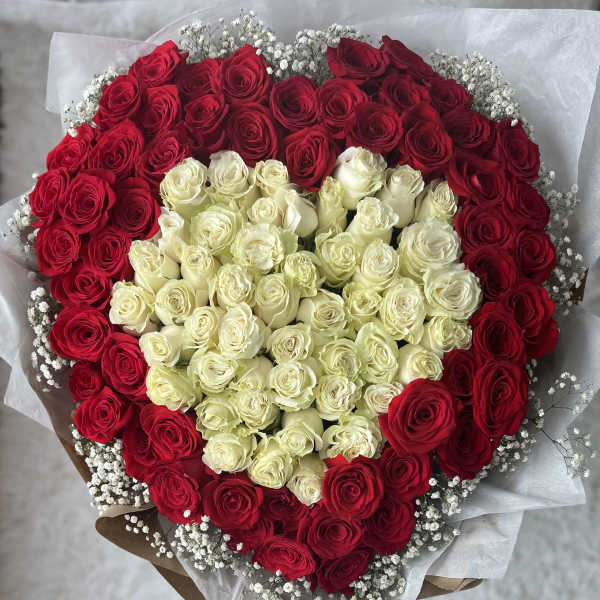 Heart-shaped bouquet of red and white roses with baby's breath