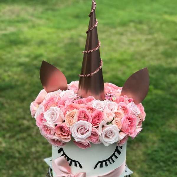 Unicorn-shaped floral arrangement with pink roses and a ribbon bow