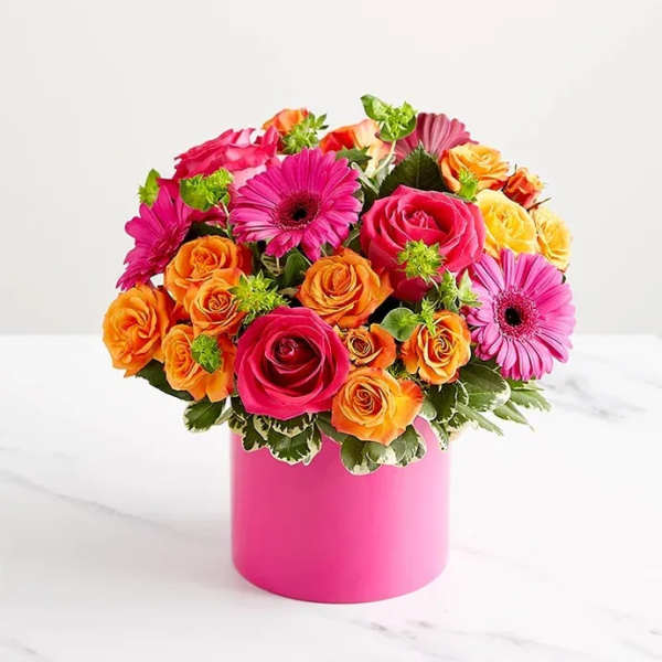 Bouquet of pink, orange, and yellow roses with gerbera daisies in a pink vase