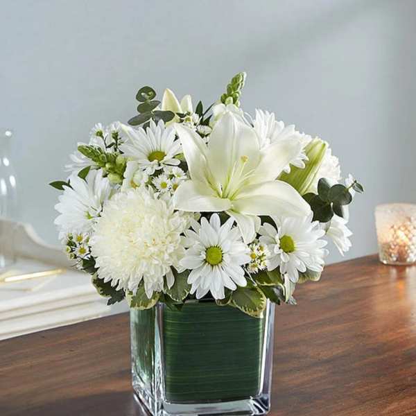 White flowers arranged in a square glass vase