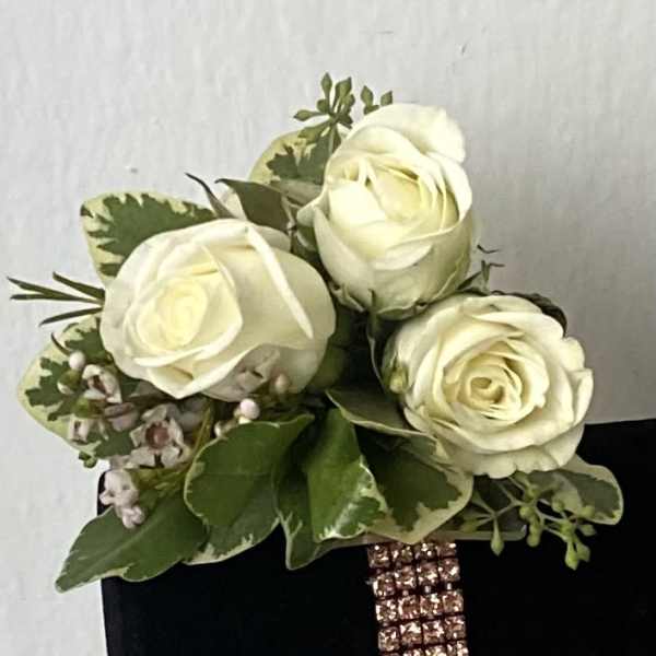White rose bouquet with green foliage on a black box