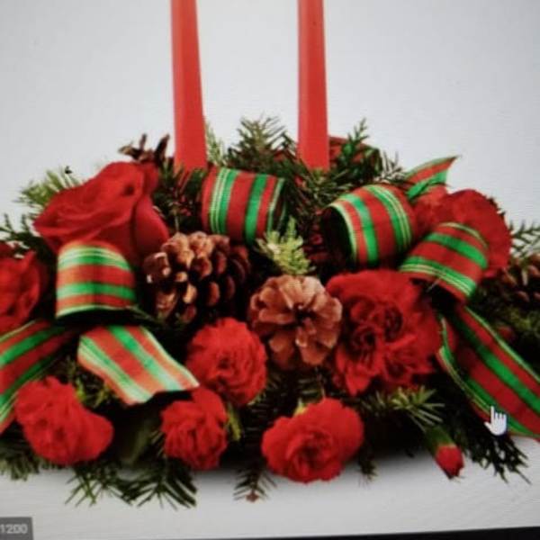 Red floral centerpiece with two tall candles and ribbon accents
