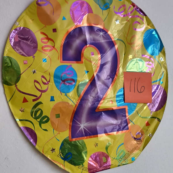 Round yellow balloon with a large purple number 2 and confetti print