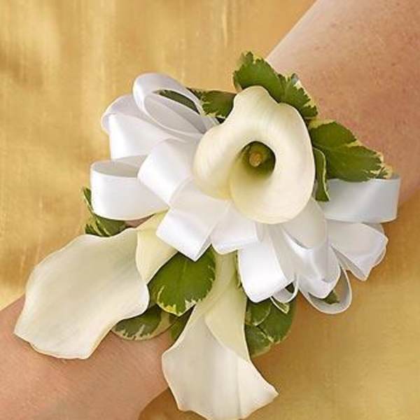 White calla lily wrist corsage with ribbon and green accents
