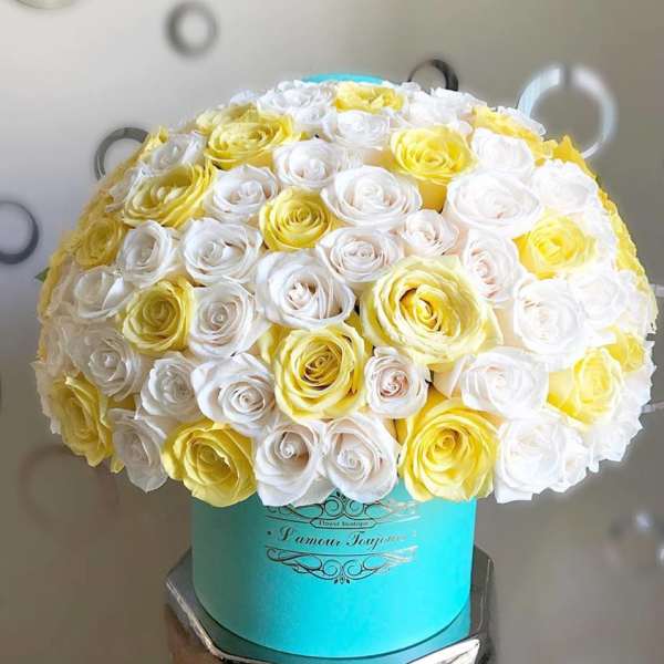 Bouquet of white and yellow roses in a turquoise hat box