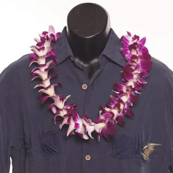 Purple orchid lei draped over a dark shirt on a mannequin